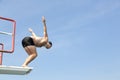 Man jumping off diving board at swimming pool