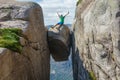 Man jumping over Kjeragbolten in Norway. Kjerag