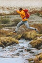 Man jumping over river in mountains hike travel adventure active Royalty Free Stock Photo