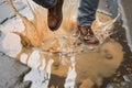 Man jumping in a puddle, splashes of dirty water. High angle view, only legs visible. AI generative image