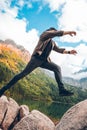 man jumping from rock at lake beach in mountains Royalty Free Stock Photo