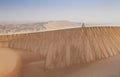 Man in kandura in a desert at sunrise