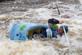 Man in a kayak with paddle in white water