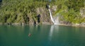 Man in kayak paddling towards the waterfall