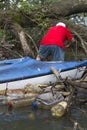 A Man In A Kayak In A River Full Of Trash