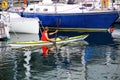 Man kayaking along the boats at Trieste marina, Italy