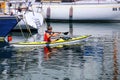 Man kayaking along the boats at Trieste marina, Italy
