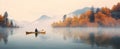 a man kayaking in an autumn colored lake Royalty Free Stock Photo