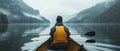 Man kayaking on a misty lake surrounded by mountains Royalty Free Stock Photo