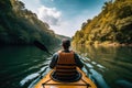 Man kayaking on the river in the forest. Active lifestyle. A persons rear view of enjoying an eco friendly activity of kayaking,