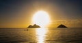 Man kayaks in front of sunrise over Pacific Ocean beach, Hawaii, USA Royalty Free Stock Photo