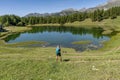 A man keen on trekking makes a stop near Lake Lod to take photos and videos with his smartphone, Aosta Valley, Italy Royalty Free Stock Photo