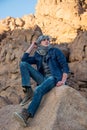 Man in a keffiyeh sitting on a rock in the desert Royalty Free Stock Photo