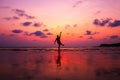 A man kick sea water and water splash at twilight sunset. Happy and relax on the beach