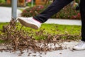 A man is kicking a pile of fallen leaves beside the flyway Royalty Free Stock Photo