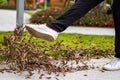 A man is kicking a pile of fallen leaves beside the flyway