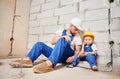 Man showing tool to child in apartment under renovation. Royalty Free Stock Photo