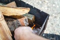 A man kindles a fire in a brazier with matches Royalty Free Stock Photo