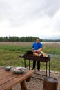 Man kindles firewood in barbecue Royalty Free Stock Photo