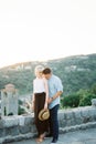 Man kisses a woman shoulder near a stone fence against a background of mountains Royalty Free Stock Photo