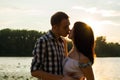 The man is kisses the young woman and hugs her at sunset background, blurred. Royalty Free Stock Photo