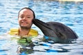 Man kissing dolphin in pool Royalty Free Stock Photo