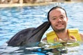 Man kissing dolphin in pool Royalty Free Stock Photo