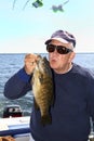 Man Kissing A Fish - Lake Ontario Smallmouth Bass Royalty Free Stock Photo