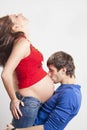 Man kissing his pregnant smiling wife at belly Royalty Free Stock Photo