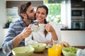 Man kissing on woman cheeks while having breakfast Royalty Free Stock Photo