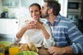 Man kissing on woman cheeks while having breakfast Royalty Free Stock Photo