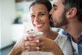 Man kissing woman on cheeks while having coffee Royalty Free Stock Photo