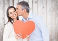 Man kissing woman holding a heart Royalty Free Stock Photo