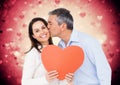 Man kissing woman holding a heart Royalty Free Stock Photo