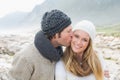 Man kissing a woman on rocky landscape