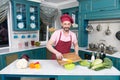 Man at kitchen cooking vegetable salad with paprika and mushrooms. Handsome chef cut orange pepper. Vegetables for healthy life Royalty Free Stock Photo