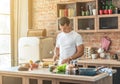 Man in the kitchen cuts a baguette