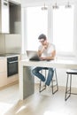 Young working man in kitchen using laptop smiling Royalty Free Stock Photo