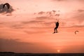 Man kitesurfer athlete jumping at sunset, silhouette at dusk man doing board greab Royalty Free Stock Photo