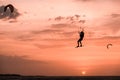 Man kitesurfer athlete jumping at sunset, silhouette at dusk man doing board greab