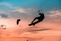 Kitesurfing lump, Man kitesurfer athlete jumping at sunset, silhouette at dusk man doing board greab