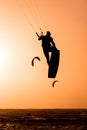 Man kitesurfing jump, kite surfer jumping at sunset on orange background between kites in the ai, kiteboarding at sunset, kitesurf Royalty Free Stock Photo