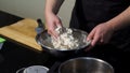 Man kneading dough with his hands in a metal bowl at the kitchen. Art. A cook preparing dough, mixing ingredients with Royalty Free Stock Photo