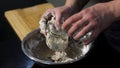 Man kneading dough with his hands in a metal bowl at the kitchen. Art. A cook preparing dough, mixing ingredients with Royalty Free Stock Photo