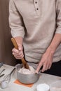 Man kneading dough in a metal mixing bowl