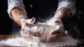 Man kneading dough on wooden background against dark wall