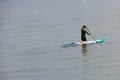 A man kneeing on a stand up paddle on Lake Constance in Kreuzlingen, Switzerland.