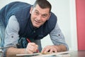 man kneeling on floor marking tile to cut Royalty Free Stock Photo