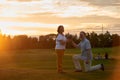 Man kneeling and giving bouquet to his wife.