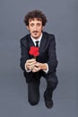 Man kneeling giving fabric rose Royalty Free Stock Photo